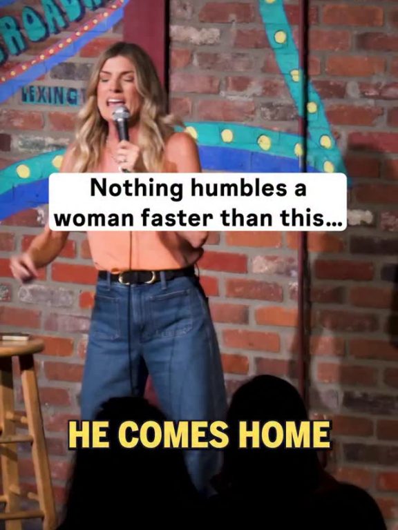 Trish Suhr performing stand-up in front of a brick wall